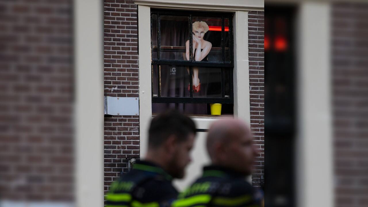 Two police officers keep watch as sex workers welcomed clients again in the Red Light District in Amsterdam, Netherlands, July 1. (AP Photo/Peter Dejong)