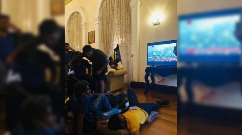 राष्ट्रपति गोटबाया राजपक्षे के आवास के अंदर प्रदर्शनकारी आराम से फर्श पर लेट कर टीवी में अपने प्रदर्शन की खबर देखते हुए।