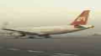 An image showing the hijacked IC-814 aircraft grounded in Kandahar with armed personnel guarding it, representing the tense moments during the 1999 hijack.