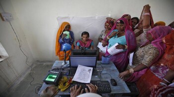 Village women stand in a queue to get themselves enrolled for the Unique Identification (UID) database system at Merta district in the desert Indian state of Rajasthan February 22, 2013. In a more ambitious version of programmes that have slashed poverty in Brazil and Mexico, the Indian government has begun to use the UID database, known as Aadhaar, to make direct cash transfers to the poor, in an attempt to cut out frauds who siphon billions of dollars from welfare schemes. Picture taken February 22, 2013. REUTERS/Mansi Thapliyal (INDIA - Tags: BUSINESS SOCIETY POVERTY SCIENCE TECHNOLOGY) - RTR3EDSU