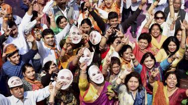 New Delhi: BJP workers and supporters, wearing the mask of Prime Minister Narendra Modi, celebrate the partys victory in the assembly elections, at party headquarters in New Delhi on Saturday. PTI Photo by Kamal Kishore (PTI3_11_2017_000038B)
