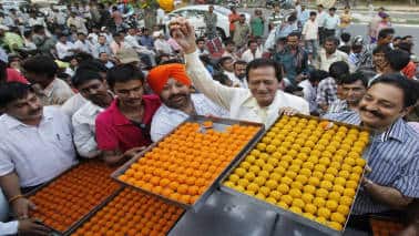 Supporters of Bharatiya Janata Party (BJP) distribute sweets during celebrations after <a href=