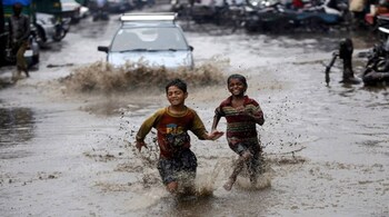 Boys run through a water logged street after heavy monsoon rains in New Delhi August 2, 2014. India's monsoon rains were nine percent below average in the week that ended July 30, the weather office said on Thursday, reflecting a patchy phase after the previous week's surplus downpours. REUTERS/Anindito Mukherjee (INDIA - Tags: SOCIETY ENVIRONMENT) - RTR40ZY1