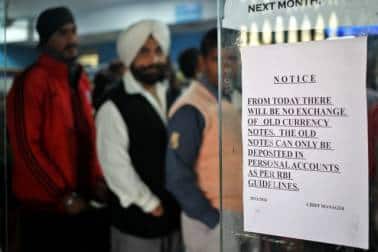 A notice is displayed at the entrance of a bank stating the end of the exchange of old high denomination banknotes, as people queue to deposit their old high denomination banknotes in Jammu, November 25, 2016. REUTERS/Mukesh Gupta - RC11DBB16CE0