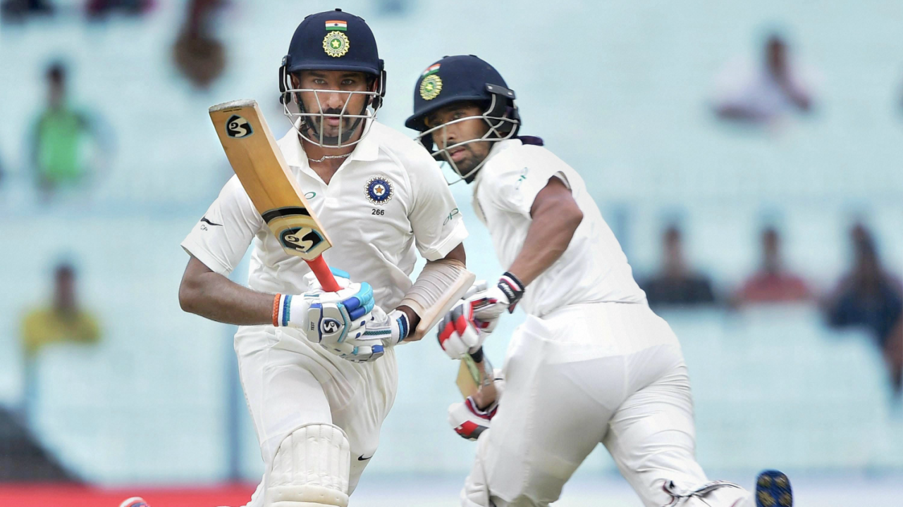 Indian batsmen C Pujara and W Saha cross each other as they complete a run during the second day of the 1st Test match against Sri Lanka at Eden Garden in Kolkata. (PTI)