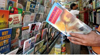 An Indian man reads a book inside a bookstore in the northeastern Indian city of Siliguri October 30, 2005. After years of being mostly restricted to the Anglophone market, Indian writers are being snapped up in the European market from France and Germany to Spain and the Netherlands. Picture taken on October 30, 2005. To match feature Arts-India-Writers. REUTERS/Rupak De Chowdhuri - RP2DSFICFNAA