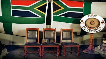 Three chairs remain empty under South African flags in a room aboard South African war vessel SAS Outenica anchored in the Pointe Noire harbour, where Zairian President Mobutu Sese Seko and rebel leader Laurent-Desire Kabila are to meet for peace negociations, May 3. The meeting to will be chaired by South African President Nelson Mandela aboard the ship in international waters. - PBEAHUMLTES