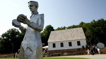 A newly erected monument of Croatian Serb scientist Nikola Tesla stands in front of his renovated house in Smiljan, central Croatia, July 10, 2006. Tesla, a Croatian Serb scientist who worked in the United States, was born 150 years ago today. REUTERS/Matko Biljak (CROATIA) - GM1DTACKQWAA