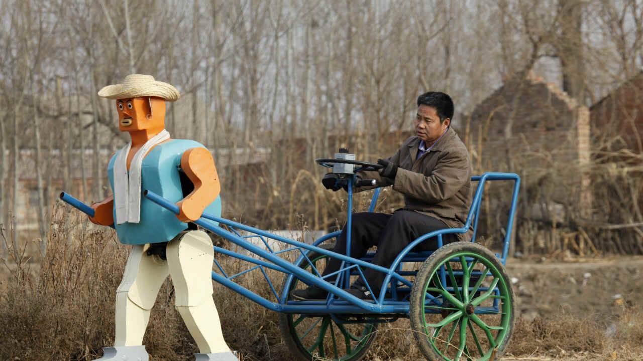 Farmer Wu Yulu drives his rickshaw pulled by a his home-made walking robot near his home in a village at the outskirts of Beijing January 8, 2009. This robot is the latest and largest development of hobby inventor Wu, who started to build robots in 1986, made of wire, metal, screws and nails found in rubbish sites. (REUTERS)
