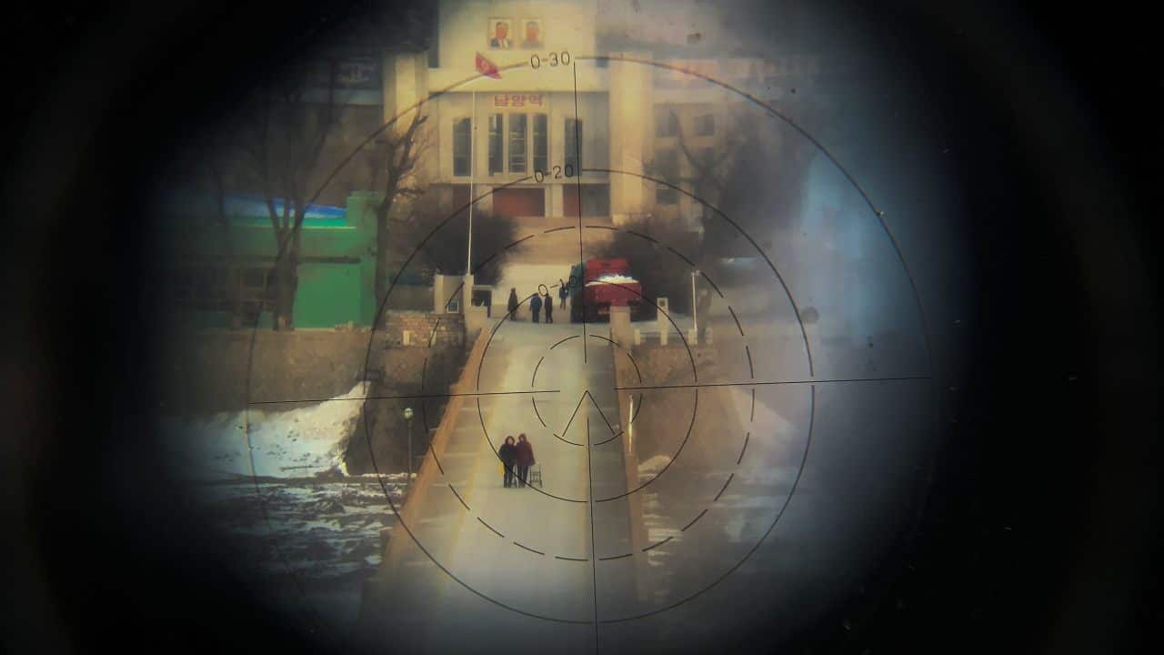 Women are photographed from the Chinese side of the border through binoculars fixed on a building on the Chinese side of the border for sightseers to get a glimpse of North Korea. These women are crossing the bridge from Namyang in North Korea to the town of Tumen in China. (Image: Reuters)