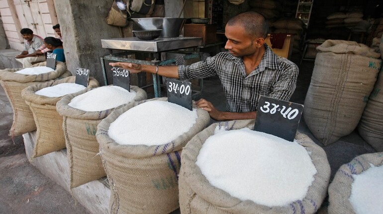 (File image) A vendor arranges price tag over sack filled with sugar at wholesale vegetable market in the western Indian city of Ahmedabad