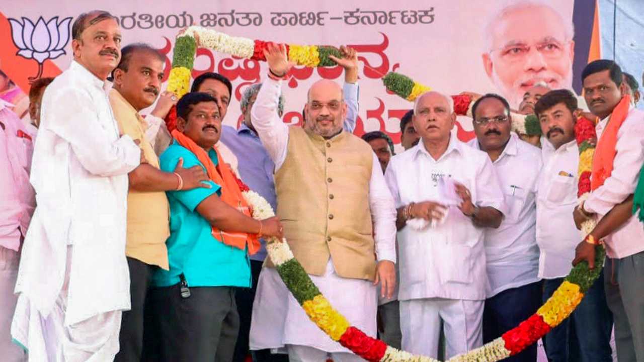 BJP National President Amit Shah with BS Yeddyurappa at a public meeting on the concluding day of “Musti Dhanya Sangraha Abhiyan” in Abbigeri Village, Gadag district of Karnataka on 12th April 2018. (PTI Photo) BJP National President Amit Shah with BS Yeddyurappa at a public meeting on the concluding day of “Musti Dhanya Sangraha Abhiyan” in Abbigeri Village, Gadag district of Karnataka on 12th April 2018. (PTI Photo)