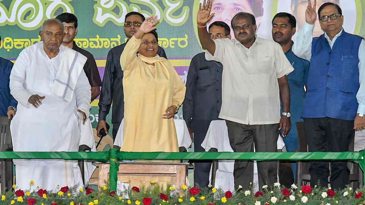 Mysore: BSP chief Mayawati flanked by former Prime Minister HD Deve Gowda (L) and JD(S) state president HD Kumaraswamy (R) waves at her supporters during a campaign for Karnataka Assembly Elections in Mysore on April 25 2018.