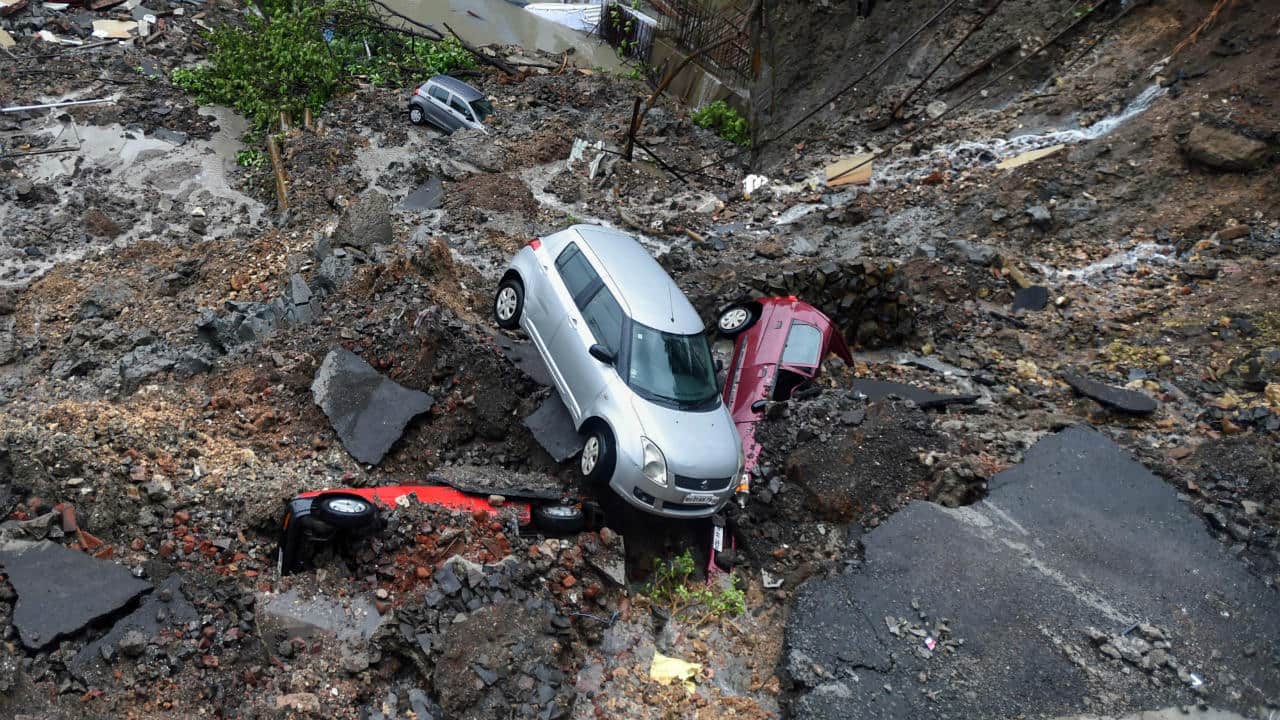 Several cars struck in debris after a wall collapsed at a construction site in Antop Hill, Wadala East area, in Mumbai. (Image: PTI)