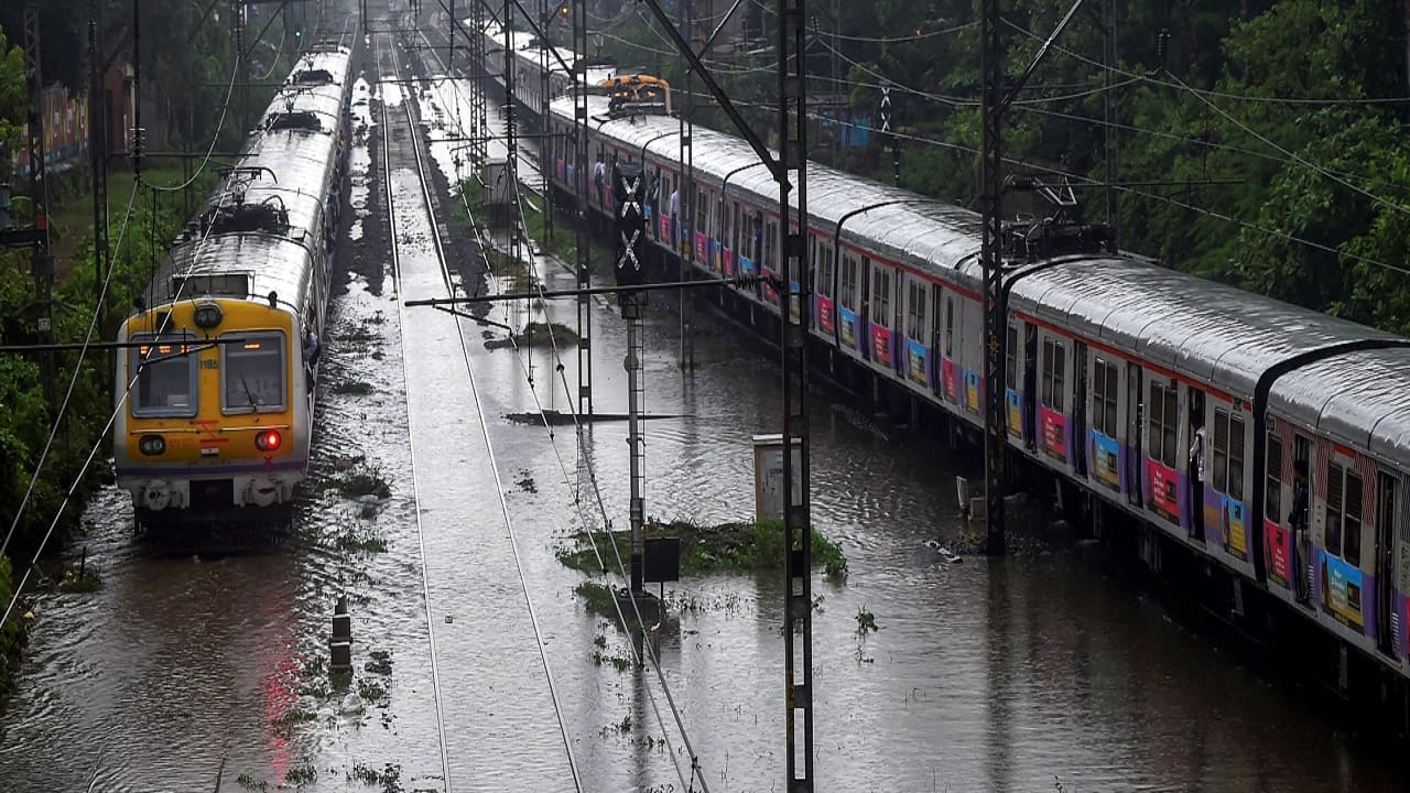 A train chugs on water-logged tracks during heavy rains, in Mumbai. Several trains were delayed along the harbour and central lines. (Image: PTI)