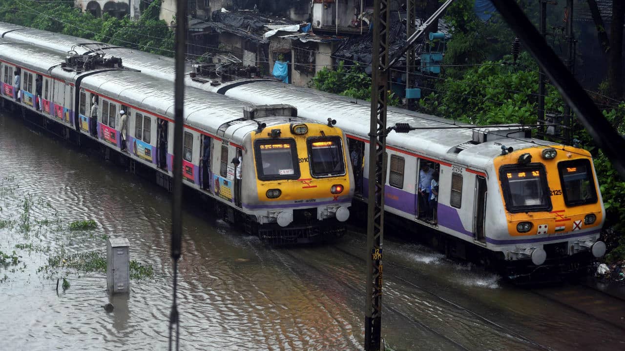  Suburban trains chug on water-logged tracks during heavy rains, in Mumbai. (Image: PTI)