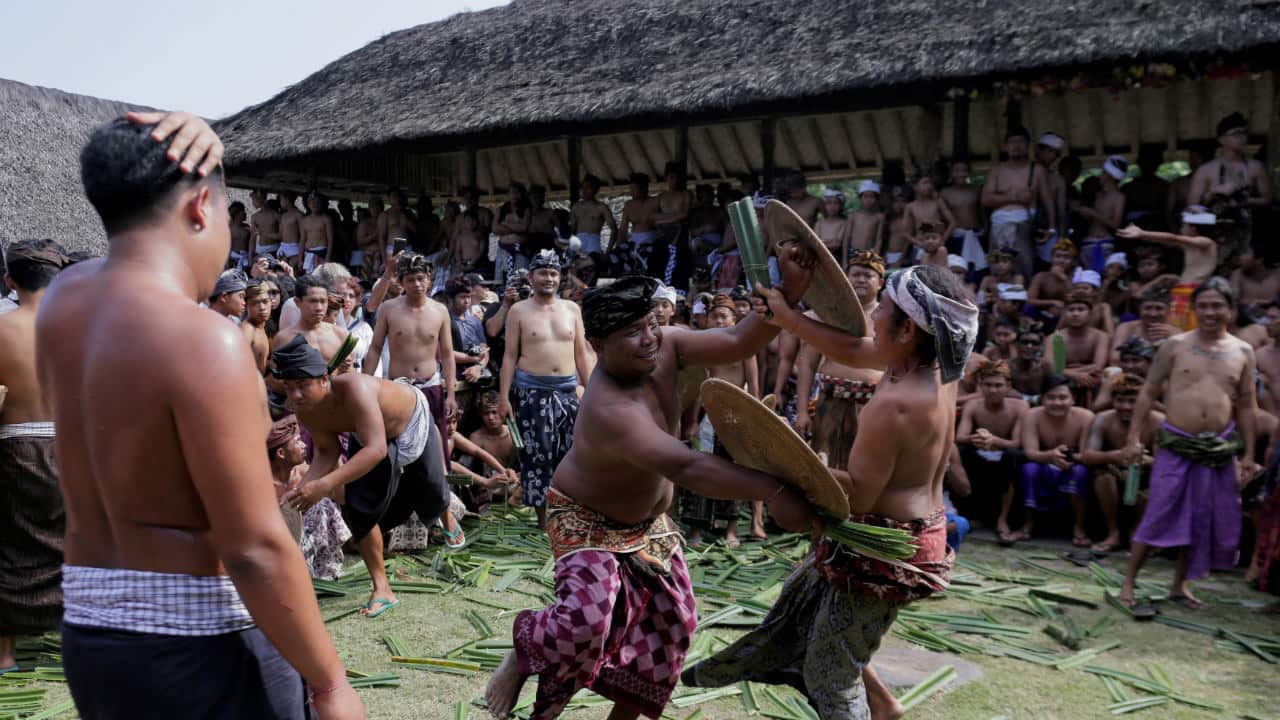 Balinese men fight using thorny pandanus leaves during the annual sacred Mekare-kare ritual, dedicated to the ‘God of War’, in Tenganan Village, Bali, Indonesia. (Image: Reuters)
