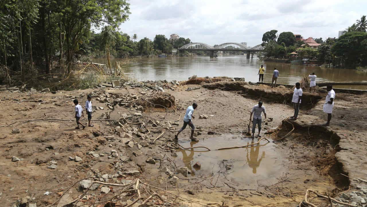 The UAE has offered Rs 700 crore fot the flood-hit state. But the Centre is unlikely to accept any foreign financial assistance. Pictured: People assessing damage caused by floods on the outskirts of Kochi. (Image: AP)