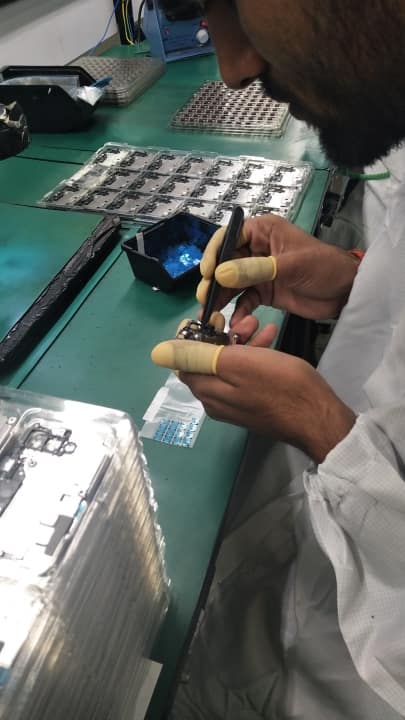 Camera component being placed around PCB. Notice the ESD "finger gloves"