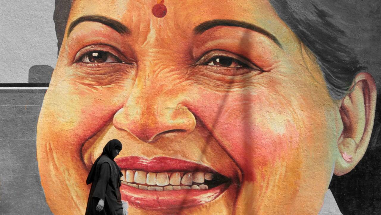A woman walks past a portrait of J Jayalalithaa in Chennai. (Image: Reuters)