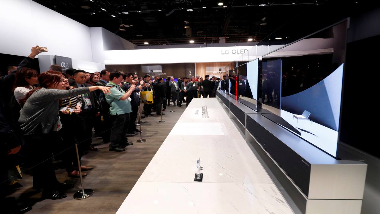 People take a look at the LG Signature OLED TV R, a television with a rollable screen that retracts into a base unit, at the LG Electronics booth during the exhibition. (Image: Reuters)