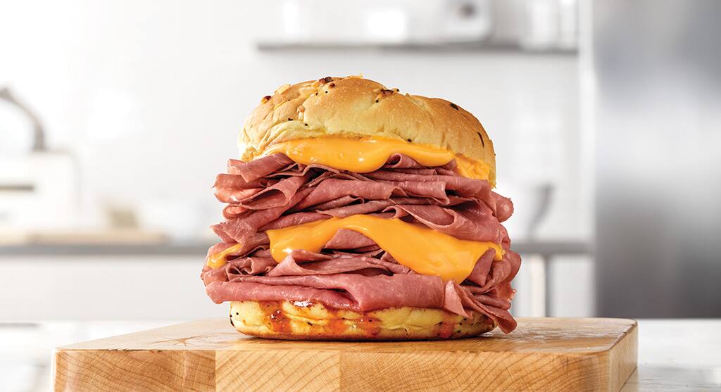 Q1. Available in Classic, Double and Half Pound sizes, this monster tops thinly sliced Roast Beef with Curly Fries, cheddar sauce, a homemade favorite sauce and Horsey sauce on a sesame seed bun. The double has two times the amount of roast beef on it than the classic, and the half-pounder boasts the most roast beef of the three options. It is seemingly named after a 1984ish apocalyptic android. What is it called? (Image: Official Website)