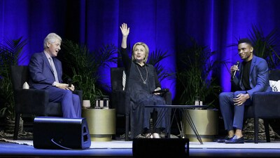 Former President Bill Clinton (left) and former Secretary of State Hillary Clinton sit with moderator Nnamdi Asomugha at The Met in Philadelphia, US, as the Clintons continue their North American speaking tour. The Clintons shared stories and anecdotes from their careers in public service and discussed topical issues. (Image: AP/PTI)