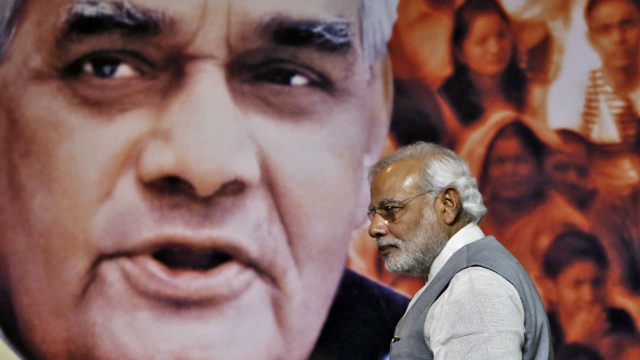 PM Modi walks in front of a picture of former prime minister Atal Bihari Vajpayee. (Reuters file image)