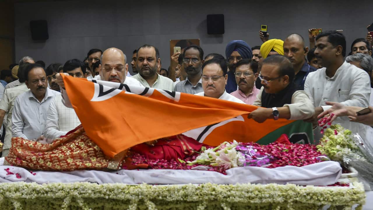 Home Minister Amit Shah lays the BJP flag over the mortal remains of former external affairs minister Sushma Swaraj, at BJP HQ in New Delhi, Wednesday, Aug 7, 2019. Swaraj, 67, passed away Tuesday night, Aug 6, 2019, after a massive cardiac arrest. (Image: PTI)