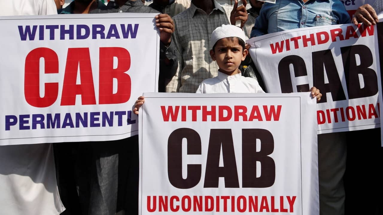 A boy holds a placard during a protest against the Citizenship Amendment Act in Mumbai. There were murmurs that the newly formed Shiv Sena-NCP-Congress government may not implement the Act, even as the Home Ministry said that states cannot not implement the bill, which was passed by the Parliament by a majority. Punjab and Kerala have also refused to implement the amended law. (Image: Reuters) 