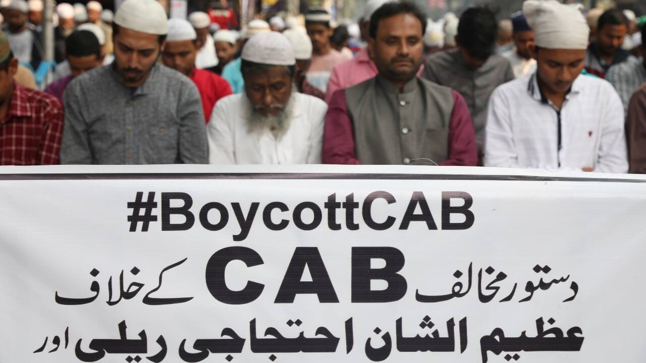 People offer Friday prayer in front of a banner before the start of a protest march against the Citizenship Amendment Bill in Kolkata on December 13. West Bengal Chief Minister Mamata Banerjee has taken out a march against the new legislation and the NRC exercise today. (Image: Reuters)