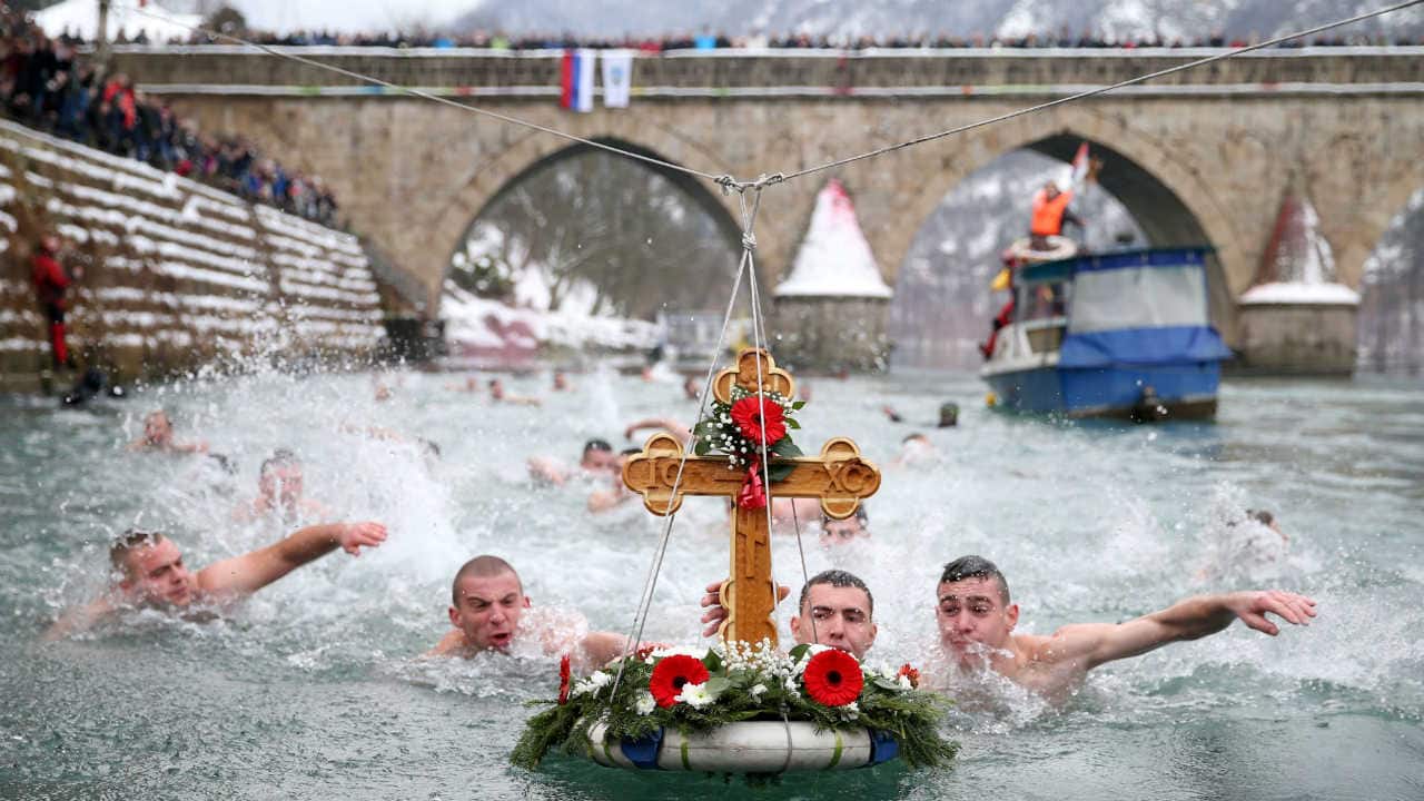 Men swim to retrieve a cross from the water during Epiphany Day celebrations in Visegrad, Bosnia and Herzegovina on January 19, 2019. (Reuters/Dado Ruvic)