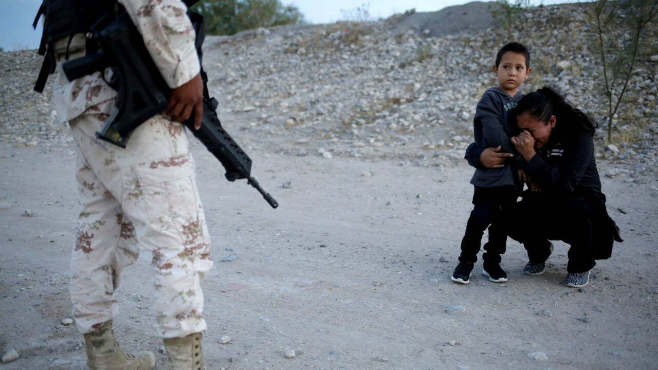 Guatemalan migrant Ledy Perez embraces her son Anthony while praying to ask a member of the Mexican National Guard to let them cross into the US, as seen from Ciudad Juarez, Mexico, July 22, 2019. (Image: Reuters/Jose Luis Gonzalez)