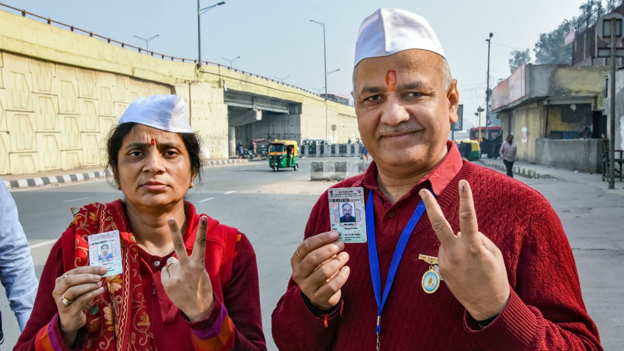 Delhi's Deputy Chief Minister Manish Sisodia and his wife Seema Sisodia Singh show their finger marked with indelible ink after casting vote during the Delhi Assembly elections at Pandav Nagar polling station. (Image: PTI)