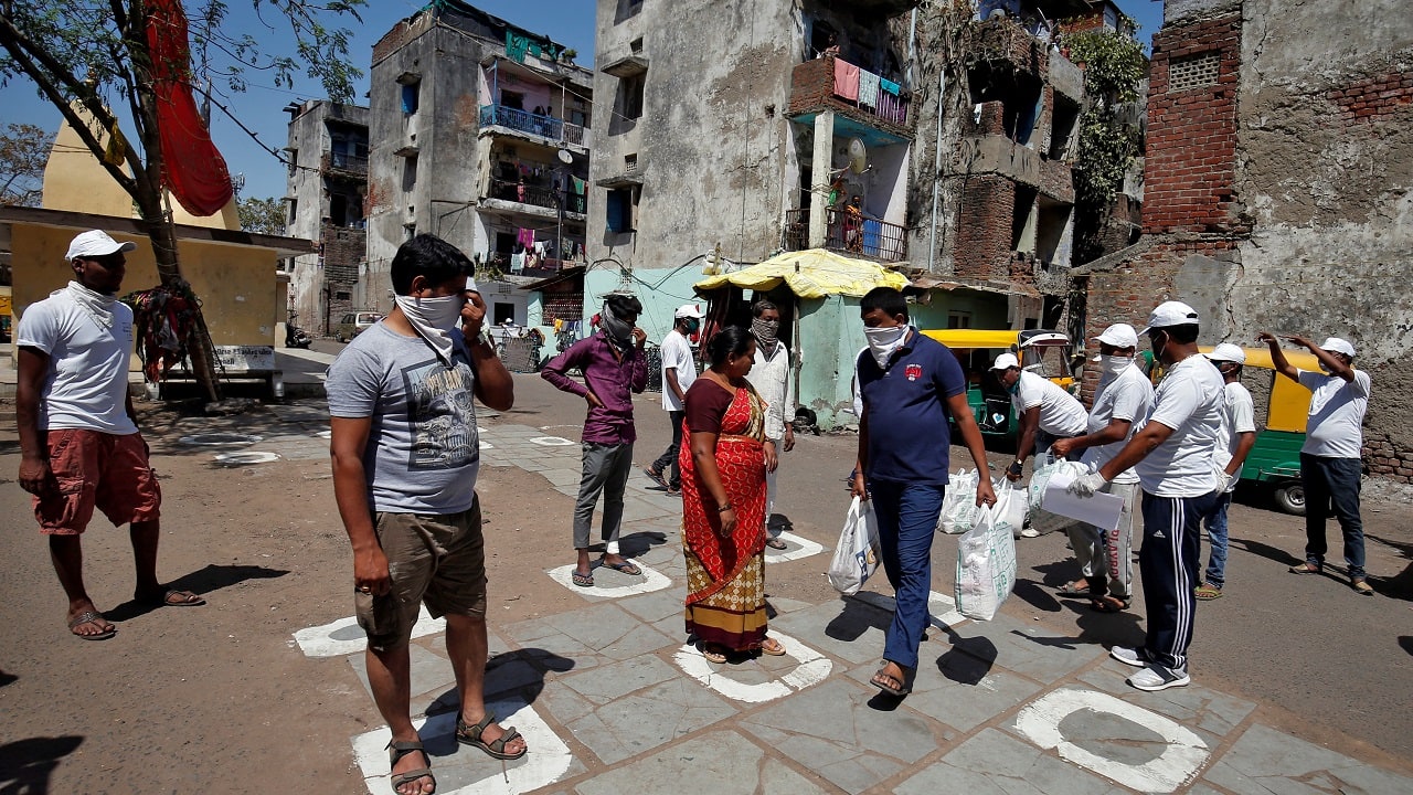 Municipal workers distribute bags of food amongst the residents as they maintain safe distance during a 21-day nationwide lockdown to limit the spreading of coronavirus disease (COVID-19), in Ahmedabad, India, March 29, 2020. REUTERS/Amit Dave - RC2OTF94EPER