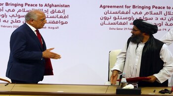 Zalmay Khalilzad (L), US envoy for peace in Afghanistan, with Mullah Abdul Ghani Baradar, the leader of the Taliban delegation, after signing an agreement between the US and the Taliban, Doha, Qatar February 29, 2020. REUTERS