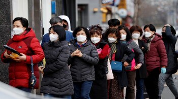 People stand in front of a drug store in Daegu, South Korea, March 3, 2020. REUTERS