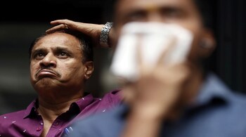 A man reacts as he looks at a screen displaying the Sensex results outside the Bombay Stock Exchange building, Mumbai, March 12. REUTERS