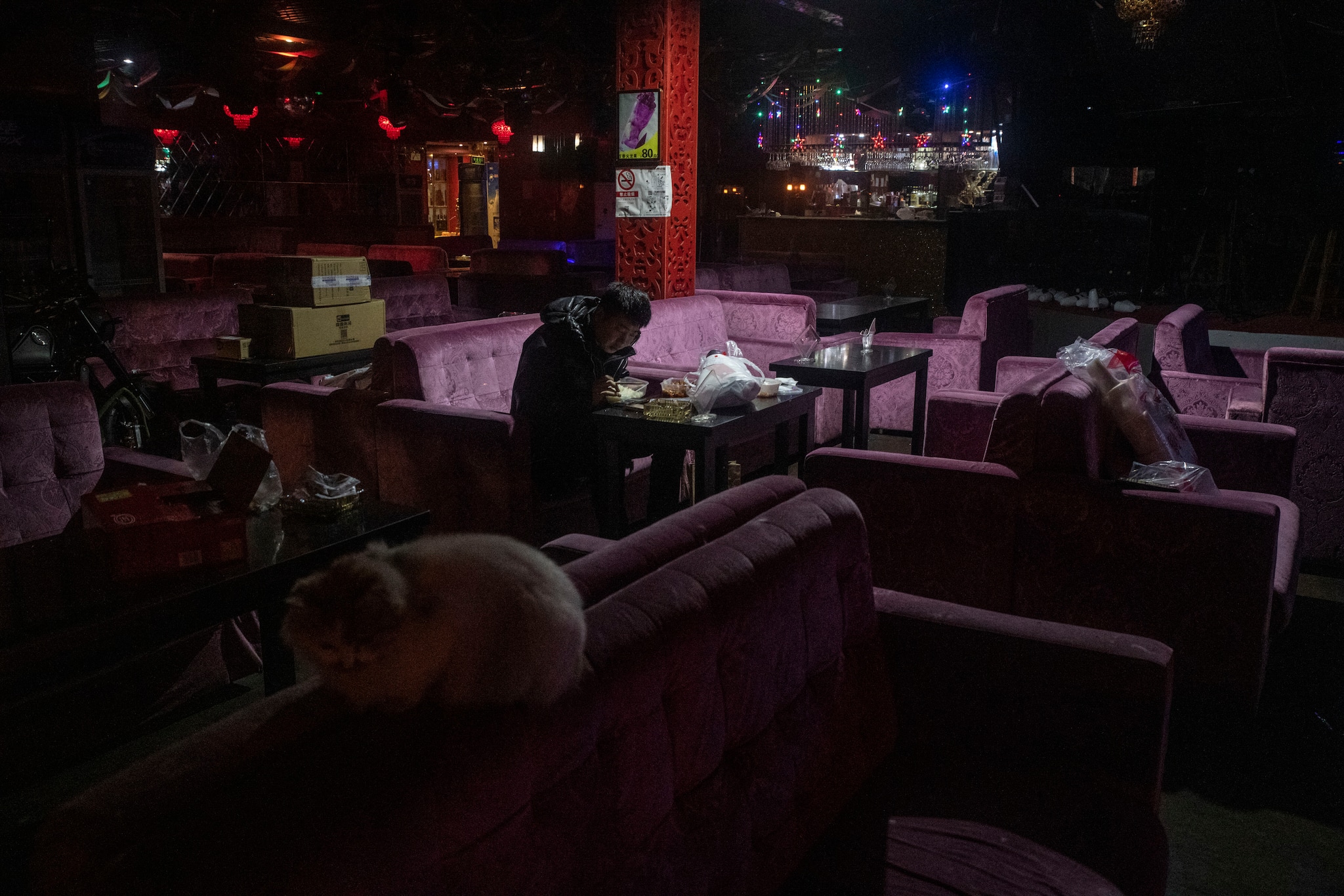A lone man having dinner in a closed bar in a neighborhood of Beijing with a usually lively nightlife, Feb. 12, 2020. (Gilles Sabrié/The New York Times)