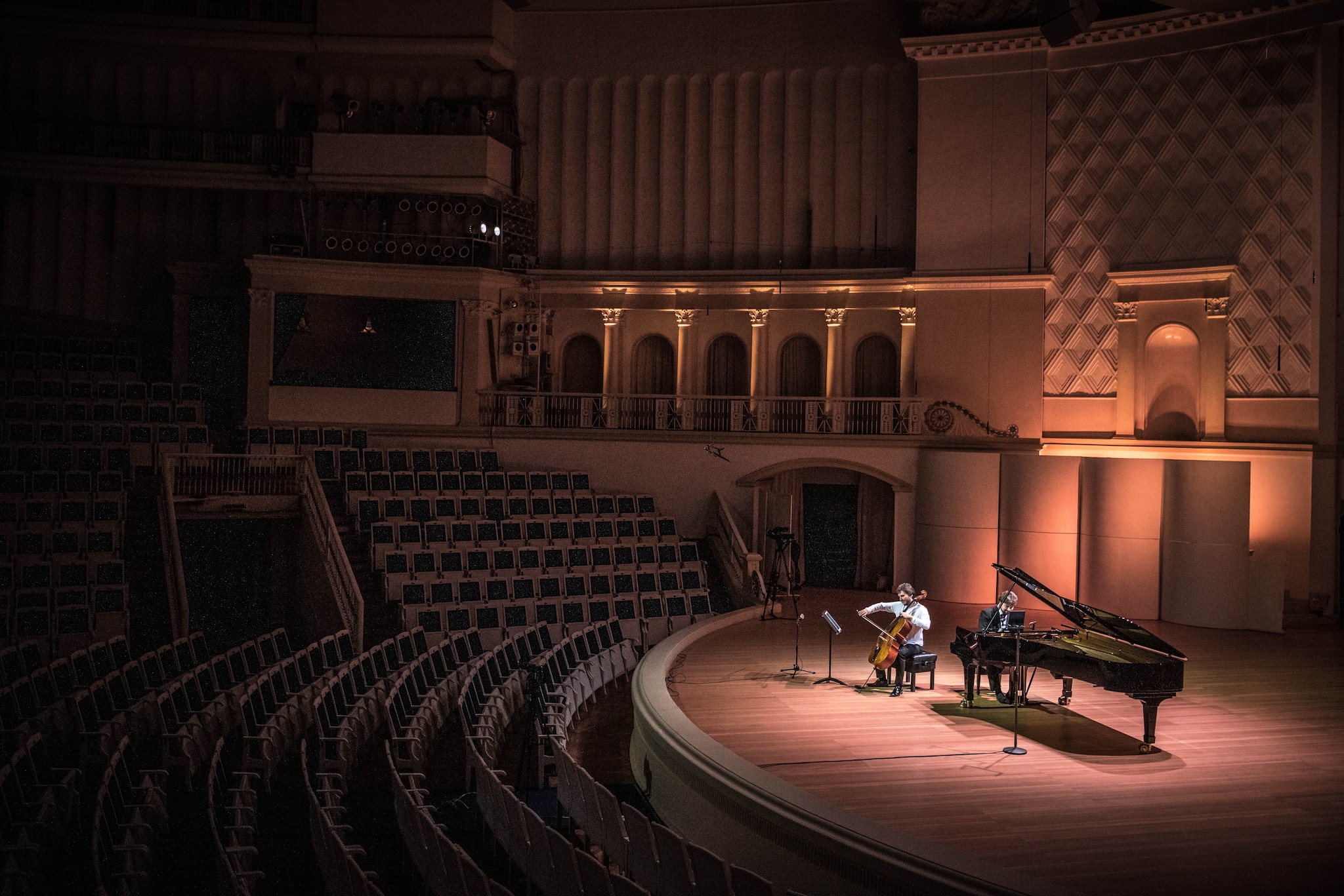 Pianist Lukas Geniusas and cello Alexandre Bouzlov performs on a stage at Tchaikovsky Concert Hall while preparing for an online broadcast, during a rehearsal in Moscow, Russia, Saturday March 21, 2020. (Sergey Ponomarev/The New York Times)