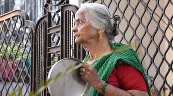 An old woman bangs utensil to cheer for emergency personnel and sanitation workers who are on the frontlines in the fight against coronavirus. (Photo: Pankaj Singh Tomar)
