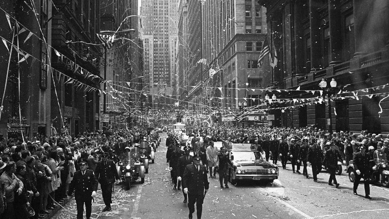 FILE - In this May 1, 1970 file photo, confetti falls from the skyscrapers in Chicago's financial district as Apollo 13 astronauts John Swigert and Jim Lovell ride in a motorcade during a parade in their honor. (AP Photo)