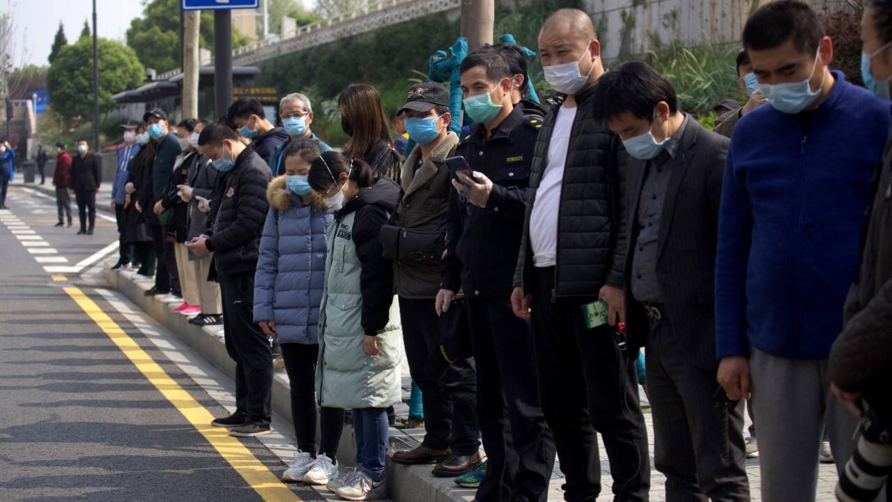 People bow their head during a moment of mourning for victims of coronavirus in China. (Image: AP) People bow their head during a moment of mourning for victims of coronavirus in China. (Image: AP)