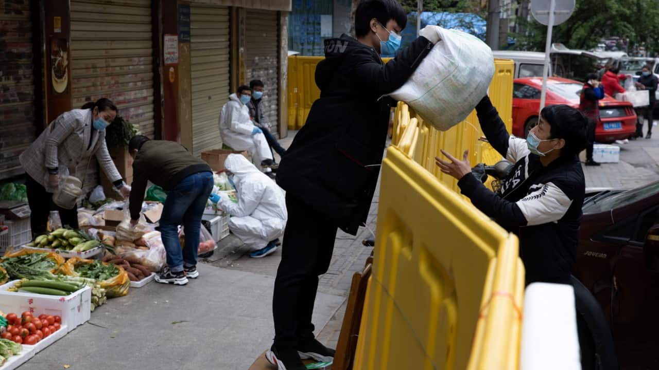 Vendors are now seen on the sidewalks wearing face masks and gloves are selling pork, tomatoes, carrots and other vegetables to shoppers in Wuhan. (Image: AP) Vendors are now seen on the sidewalks wearing face masks and gloves are selling pork, tomatoes, carrots and other vegetables to shoppers in Wuhan. (Image: AP)