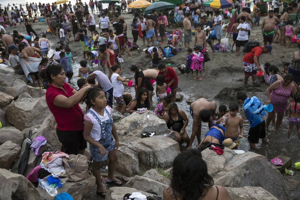 People put on their street clothes after spending a day at Agua Dulce beach in Lima, ...