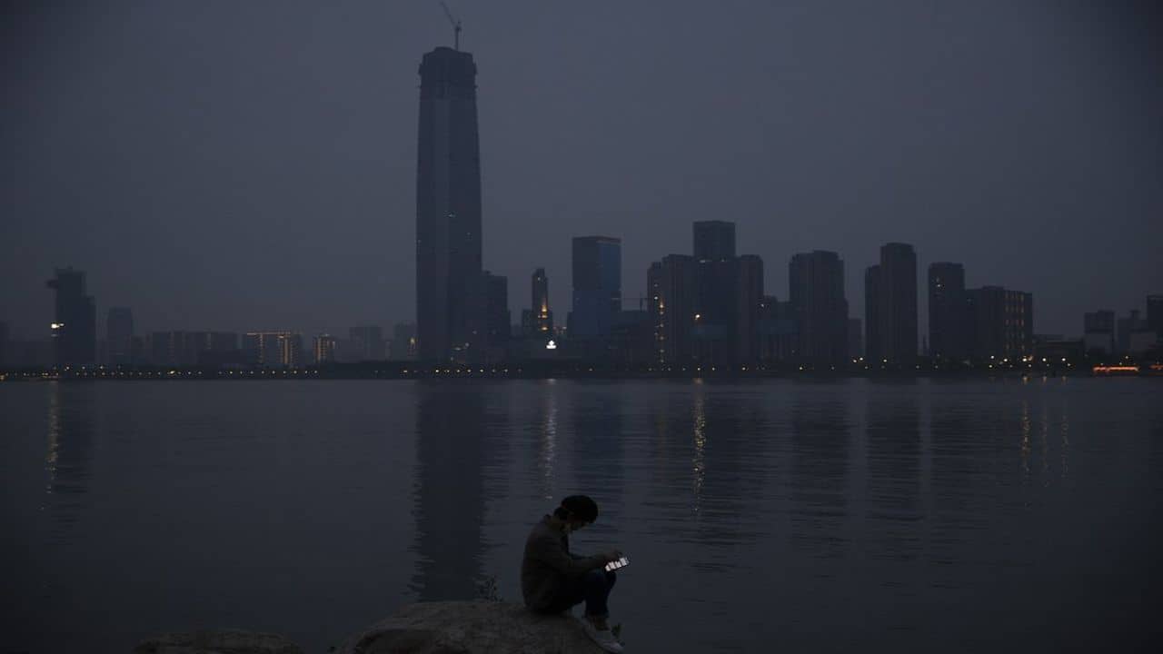 A child wearing a mask against the new coronavirus takes a nap along the Yangtze River in Wuhan in central China's Hubei province. (AP)