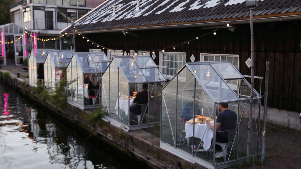 A restaurant tests servers providing drinks and food to models pretending to be guests in safe 'quarantine greenhouses' in which clients can dine in Amsterdam, on May 5. (Image: Reuters) A restaurant tests servers providing drinks and food to models pretending to be guests in safe 'quarantine greenhouses' in which clients can dine in Amsterdam, on May 5. (Image: Reuters)