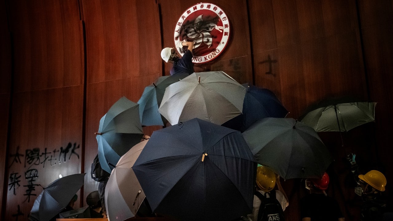 A man sprays paint over the Regional Emblem of Hong Kong after anti-extradition bill protesters stormed the Legislative Council Complex on the 22nd anniversary of the handover from British to Chinese rule, destroying pictures and daubing walls with graffiti in Hong Kong, China July 1, 2019. (Image: Reuters /Tyrone Siu)