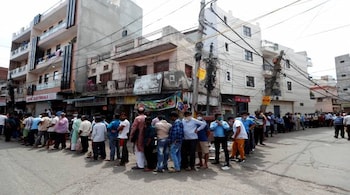 People stand in a queue to buy liquor outside a wine shop in New Delhi on May 4. (REUTERS)