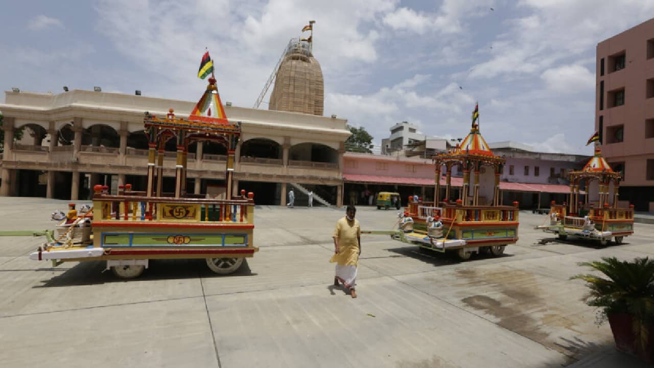 A man walks past chariots on the eve of the annual chariot procession of Hindu deity Jagannath, in Ahmedabad. (Image: AP) A man walks past chariots on the eve of the annual chariot procession of Hindu deity Jagannath, in Ahmedabad. (Image: AP)
